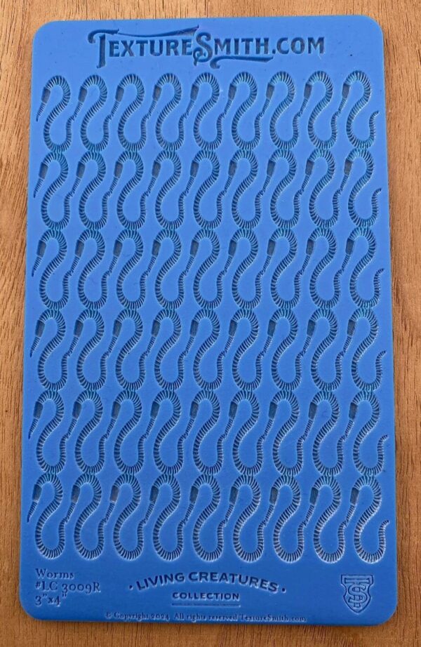 Blue sheet with repeated footprint patterns on a wooden surface.