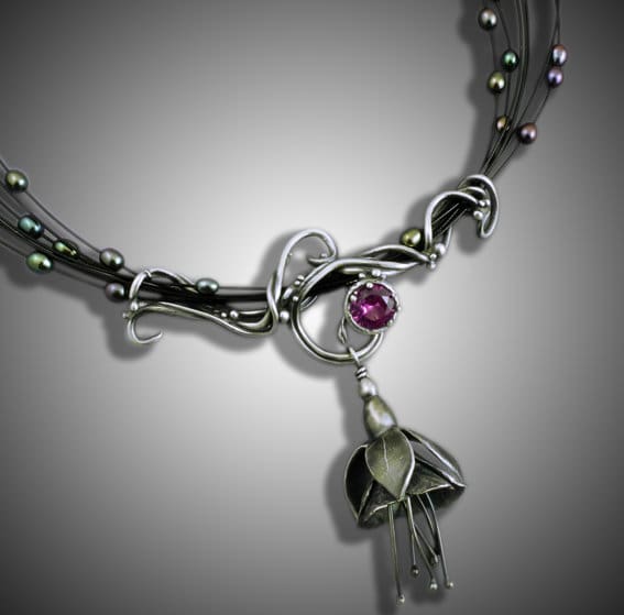 Elegant silver necklace with a purple gemstone and leaf pendant.