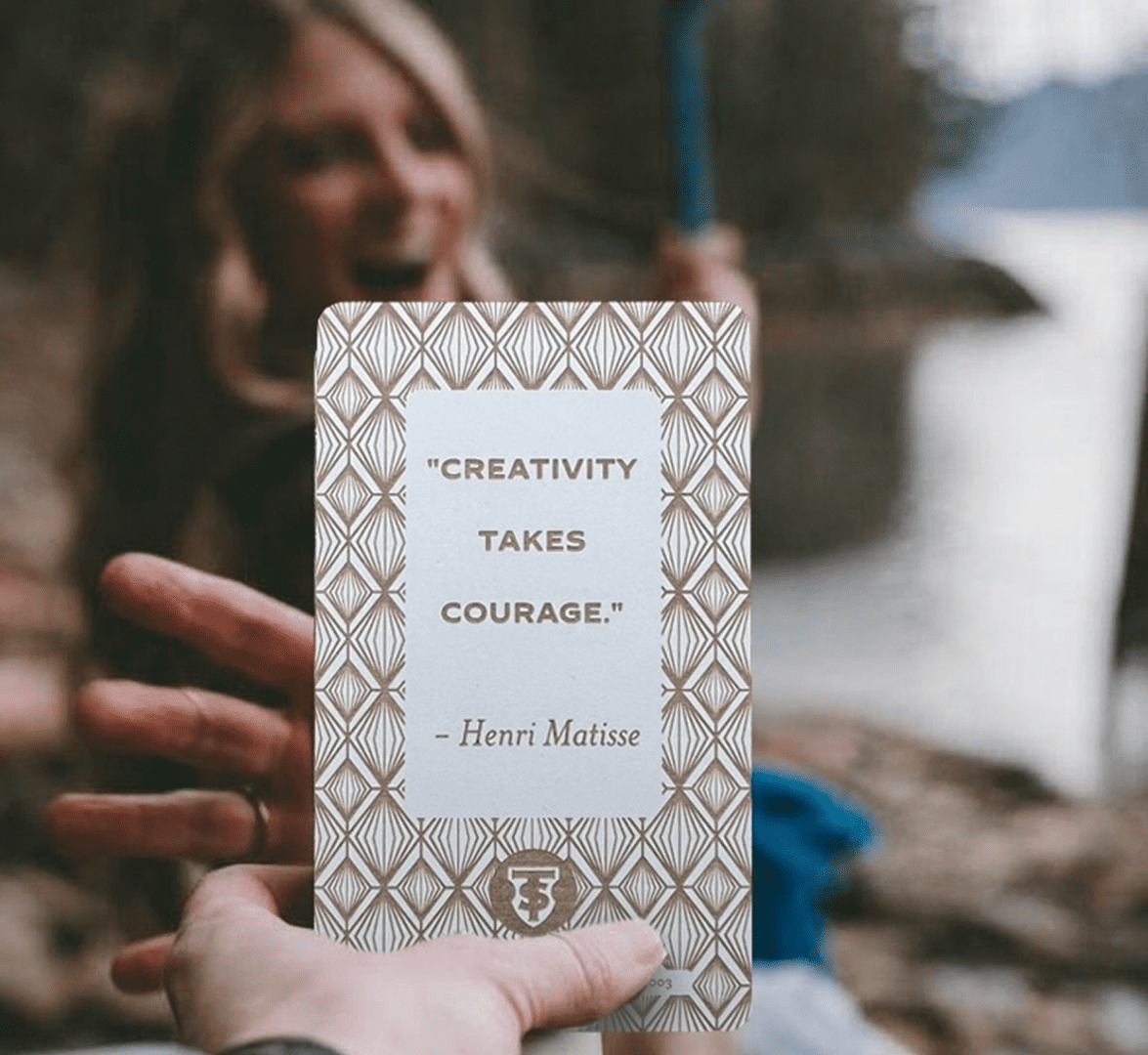 Person holding a card with an inspirational quote by Henri Matisse.
