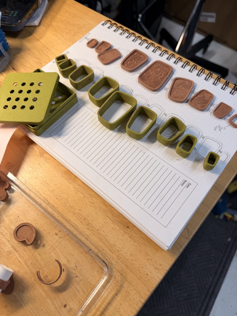The light bronze metal clay panels arranged beside the Slip Fit Modular cutters on Rachael’s sketchbook.